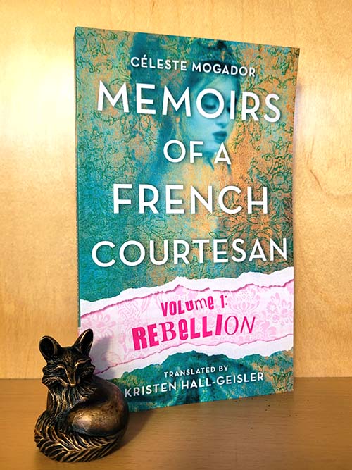 Memoirs of a French Courtesan Volume 1: Rebellion by Celeste Mogador, translated by Kristen Hall-Geisler. Paperback book on a wooden shelf with a small bronze fox.